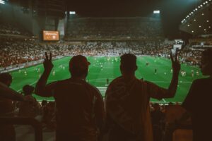 Football fans watching a live match in a packed stadium during the 2026 FIFA World Cup, showcasing the excitement and atmosphere of international football.