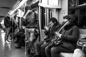 "Why We Can't Stop Scrolling: The Psychology of Social Media shown through subway commuters engrossed in their smartphones, highlighting social media addiction and endless scrolling."