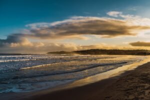 Beach walking for stress relief with peaceful ocean waves, golden sunset, and a relaxing shoreline