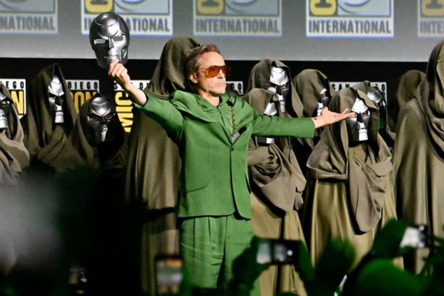 Robert Downey Jr. on stage with Doctor Doom imagery, symbolizing Avengers Doomsday and Marvel’s shifting direction